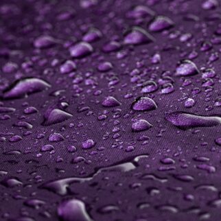 Background of a Macro shot of raindrops on a purple embrela