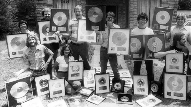 black and white photo of people holding records