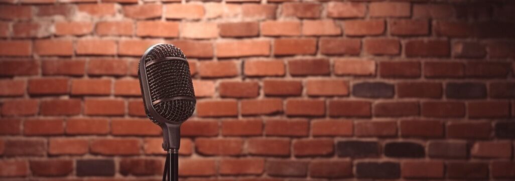 Stand up comedy stage microphone background brick wall.